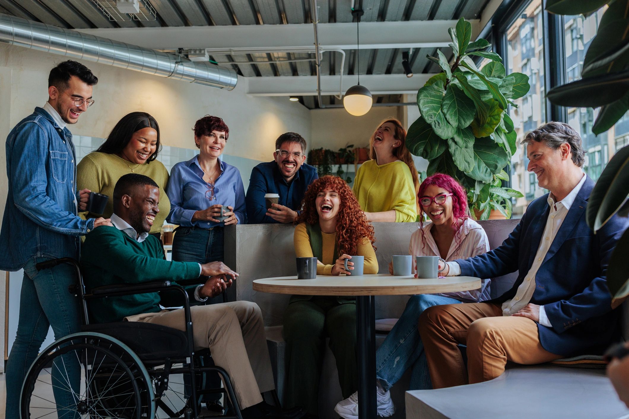 Occupational therapist and adult with disability talking and laughing together in a comfortable lounge room